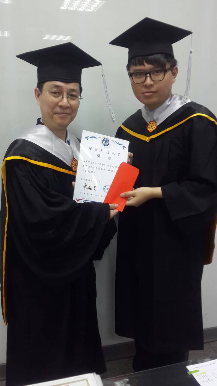 主任與學生著畢業學士服拿奬學金照片(同學為右邊男生)